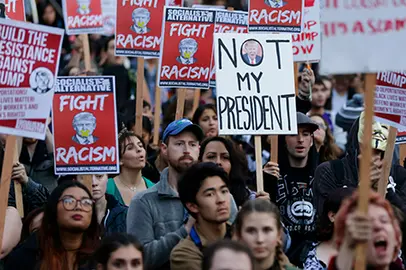 Protesters hold signs during a protest against the election of President-elect Donald Trump, Wednesday, Nov. 9, 2016, in downtown Seattle. (AP Photo/Ted S. Warren)